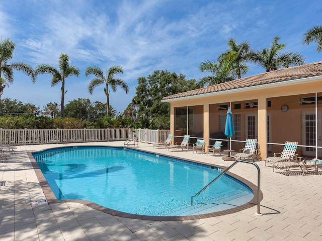 view of swimming pool featuring ceiling fan and a patio