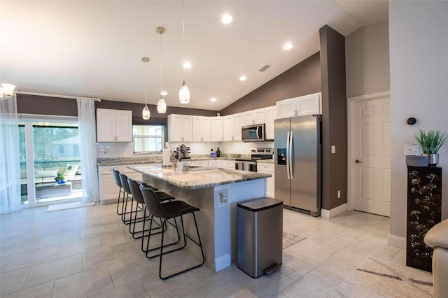 kitchen featuring light stone countertops, white cabinetry, a center island with sink, and stainless steel appliances