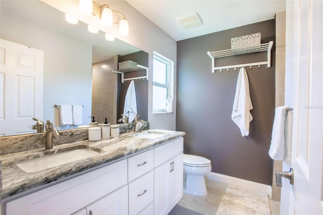 bathroom featuring tile patterned flooring, vanity, and toilet