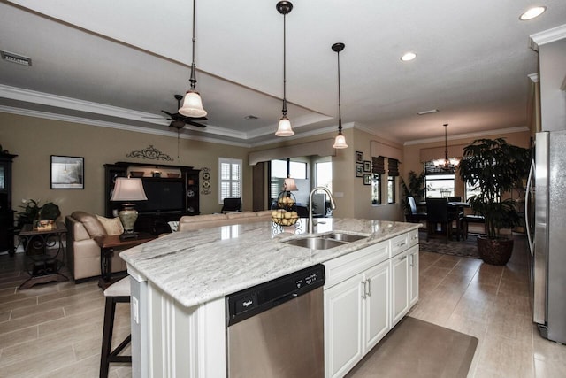 kitchen featuring sink, light stone counters, an island with sink, white cabinets, and appliances with stainless steel finishes