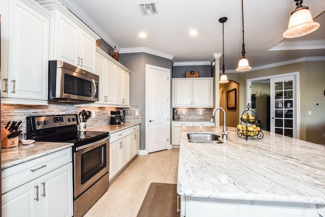 kitchen with pendant lighting, backsplash, sink, appliances with stainless steel finishes, and light stone counters