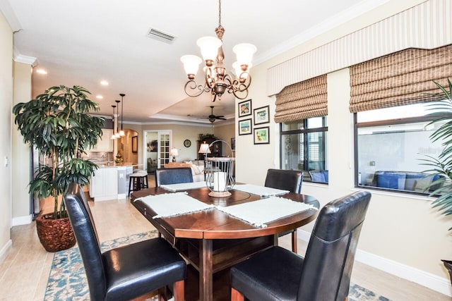 dining room featuring ceiling fan with notable chandelier, light wood-type flooring, and crown molding