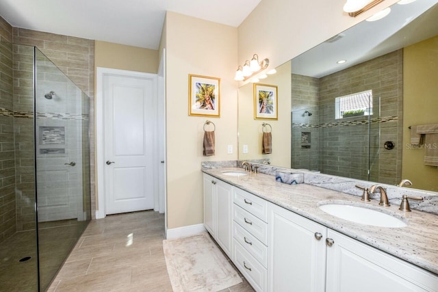 bathroom featuring a tile shower, tile patterned flooring, and vanity