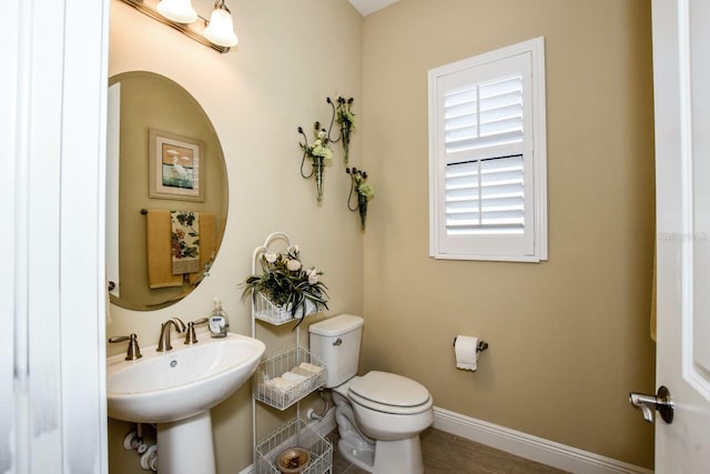 bathroom with hardwood / wood-style floors, toilet, and sink