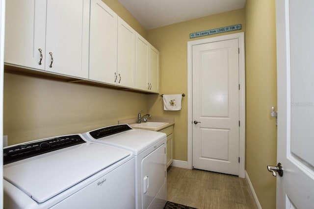 laundry area with cabinets, independent washer and dryer, and sink