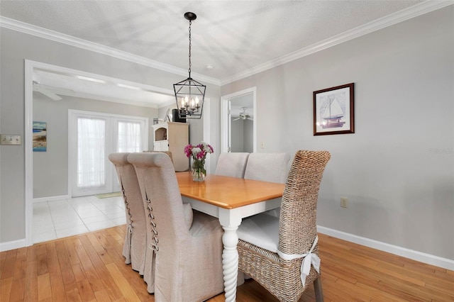 dining space with a textured ceiling, a chandelier, crown molding, and light hardwood / wood-style flooring