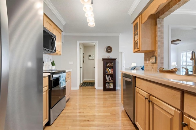 kitchen featuring light wood-type flooring, stainless steel appliances, ornamental molding, and backsplash