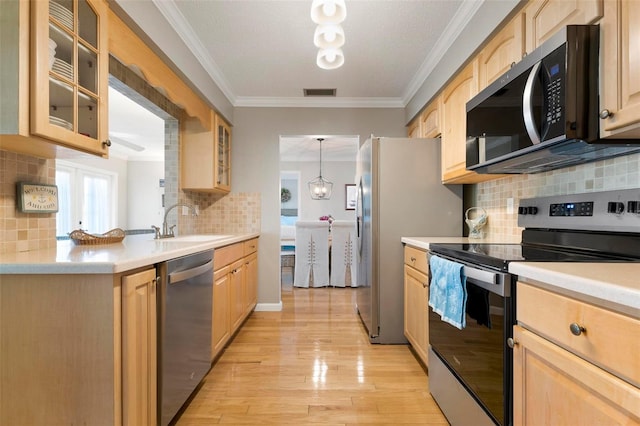 kitchen featuring appliances with stainless steel finishes, sink, light brown cabinets, light hardwood / wood-style floors, and hanging light fixtures