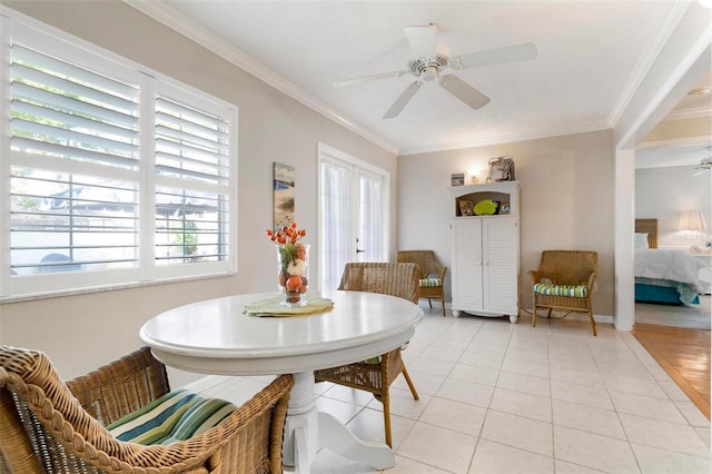 tiled dining space with crown molding, plenty of natural light, and ceiling fan