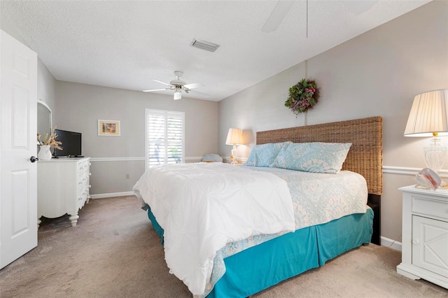 bedroom with carpet flooring, ceiling fan, and a textured ceiling