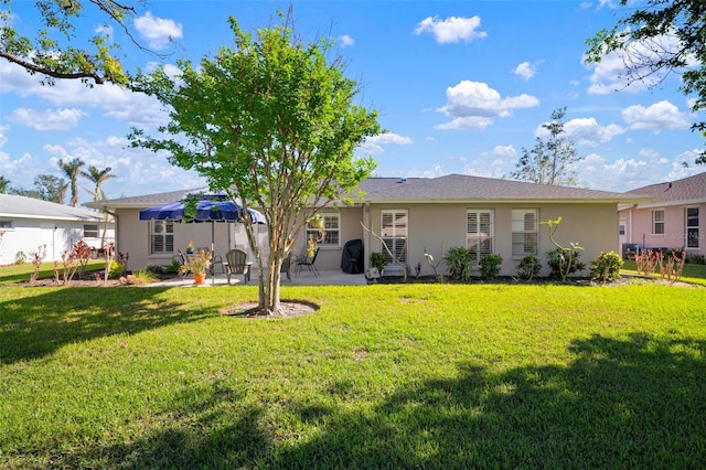 back of property with a yard and a patio