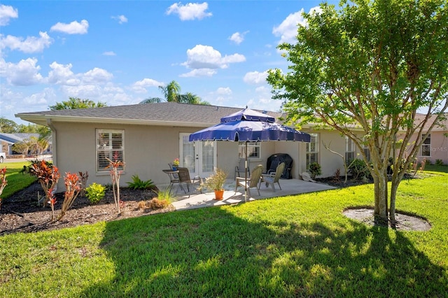 back of property with a yard and a patio