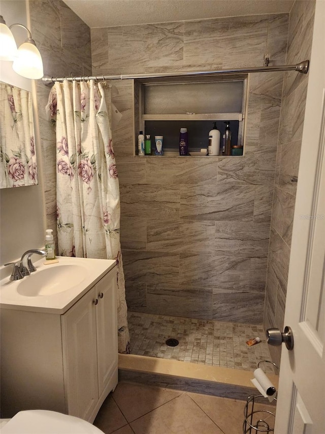 bathroom with toilet, a shower with curtain, vanity, and tile patterned floors