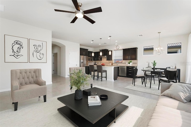 living room with ceiling fan with notable chandelier