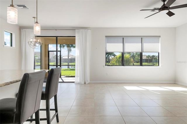 unfurnished dining area with light tile patterned floors and ceiling fan with notable chandelier