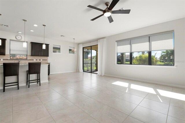 unfurnished living room featuring ceiling fan and light tile patterned floors