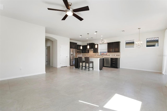 tiled living room with ceiling fan with notable chandelier