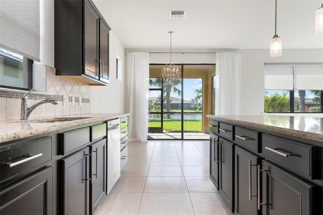 kitchen with light stone countertops, sink, a wealth of natural light, and tasteful backsplash