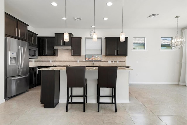 kitchen with pendant lighting, stainless steel appliances, and a kitchen island