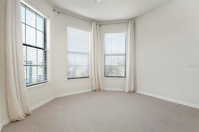 carpeted spare room featuring a healthy amount of sunlight