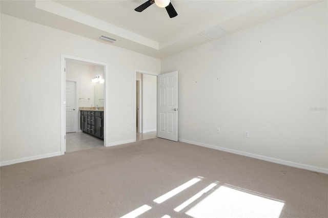 unfurnished bedroom with ensuite bathroom, ceiling fan, and light colored carpet