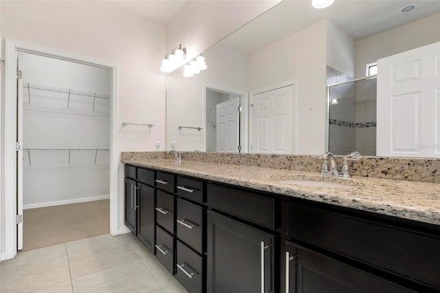 bathroom featuring tile patterned flooring, vanity, and a shower with door