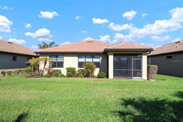 back of house featuring a lawn and a sunroom