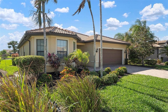 mediterranean / spanish-style home featuring a garage and a front yard