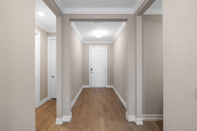 hall with light hardwood / wood-style floors and ornamental molding