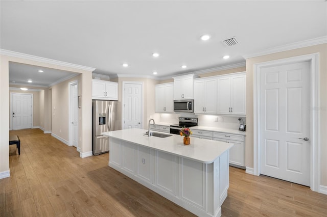 kitchen featuring white cabinets, a center island with sink, sink, appliances with stainless steel finishes, and light hardwood / wood-style floors