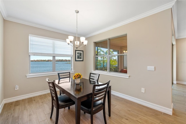 dining room with light hardwood / wood-style flooring, a water view, and a healthy amount of sunlight