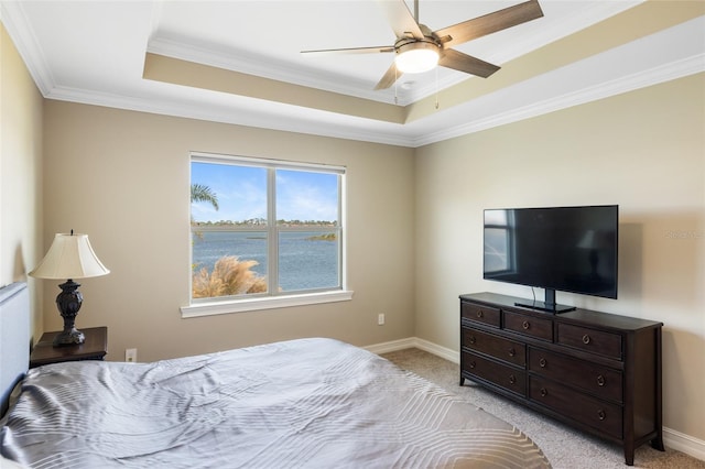 carpeted bedroom featuring a raised ceiling, ceiling fan, and crown molding