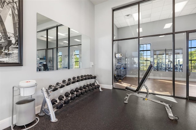 660 Ravello Blvd, Nokomis, FL 34275 - exercise room featuring baseboards, a towering ceiling, and a drop ceiling