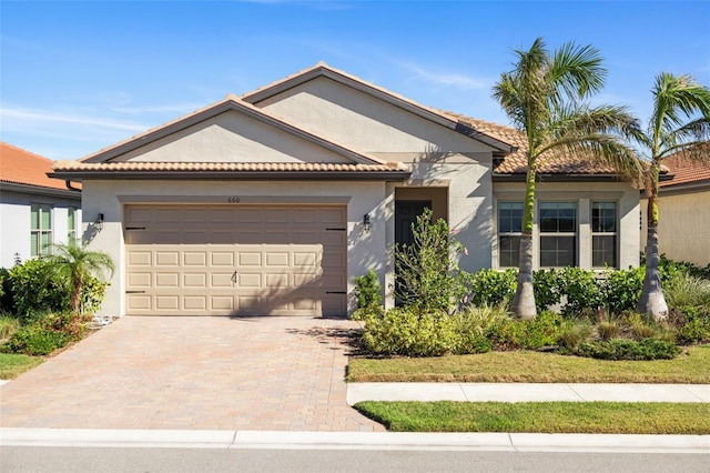 660 Ravello Blvd, Nokomis, FL 34275 - view of front facade featuring an attached garage, stucco siding, decorative driveway, and a tiled roof