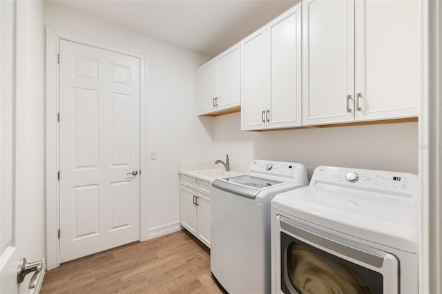 660 Ravello Blvd, Nokomis, FL 34275 - laundry room featuring washer and dryer, cabinet space, and light wood finished floors