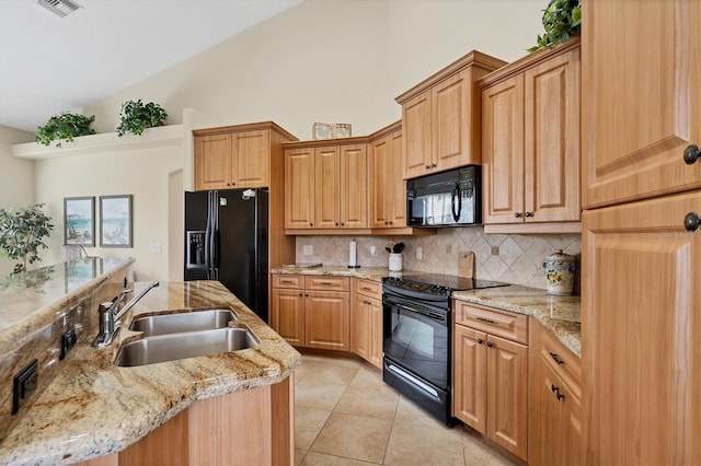 kitchen featuring decorative backsplash, sink, light stone counters, and black appliances