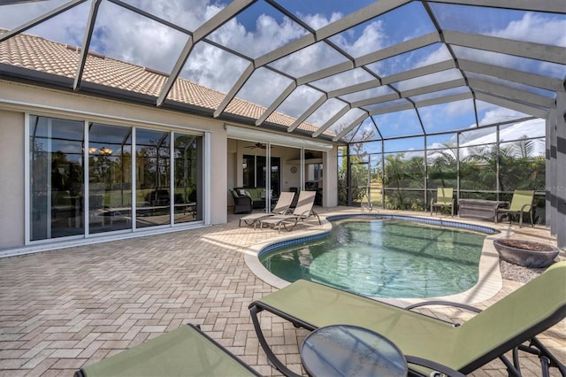 view of swimming pool featuring a patio area, ceiling fan, and glass enclosure