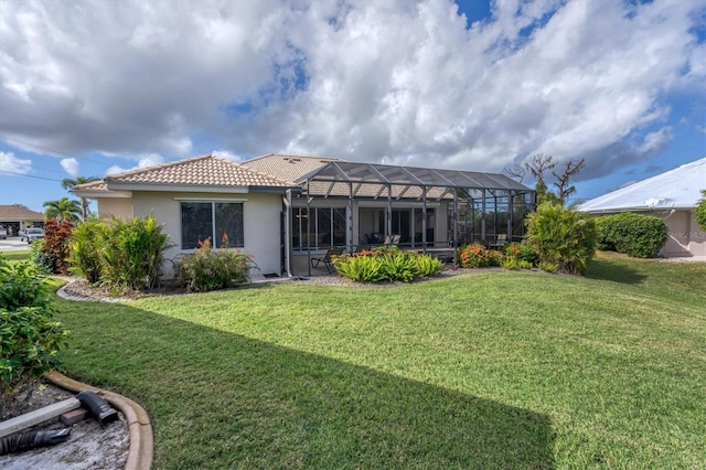 rear view of property featuring glass enclosure and a yard