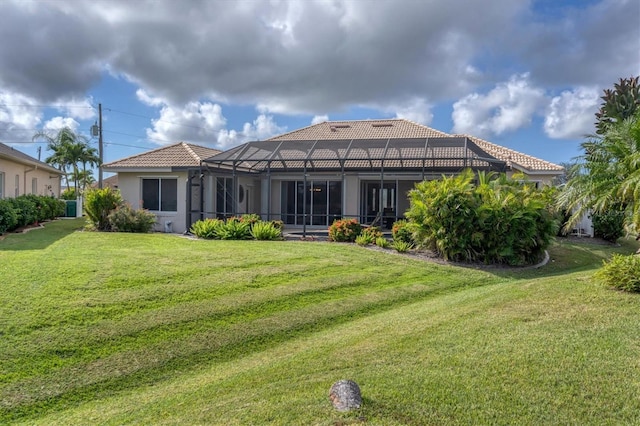 back of house featuring a lanai and a yard