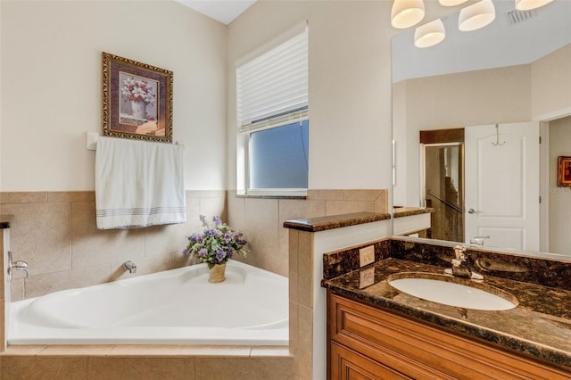 bathroom featuring vanity and independent shower and bath