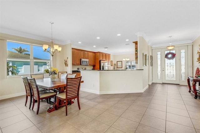 dining room with a wealth of natural light, crown molding, light tile patterned floors, and a chandelier