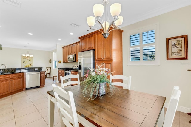 dining room featuring crown molding, light tile patterned floors, sink, and a chandelier