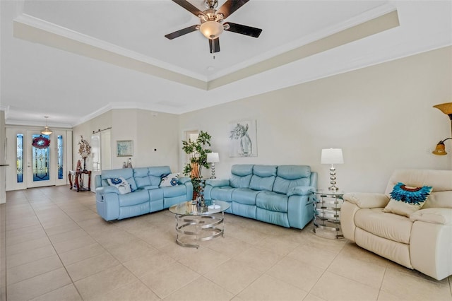 tiled living room with ceiling fan, crown molding, and a tray ceiling