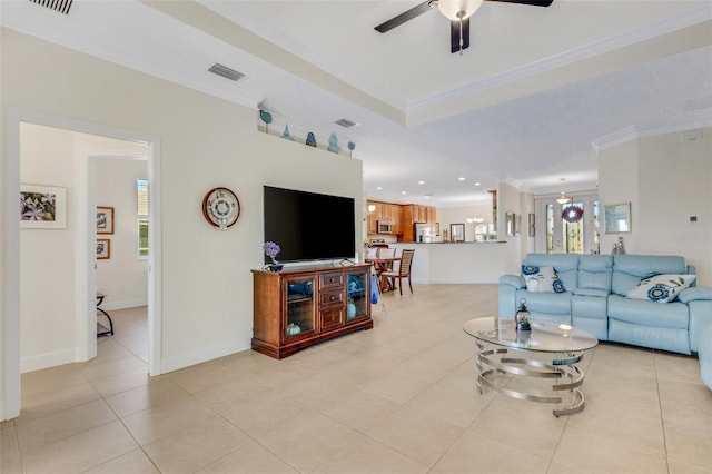 living room with a wealth of natural light, light tile patterned floors, ornamental molding, and ceiling fan