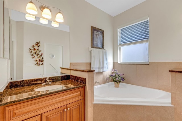 bathroom featuring vanity and tiled tub