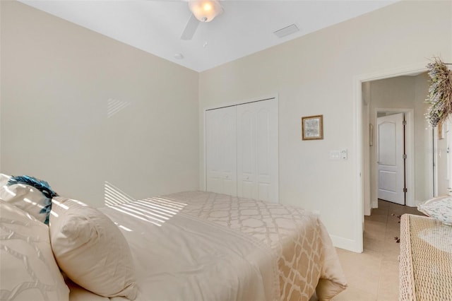 tiled bedroom with ceiling fan and a closet