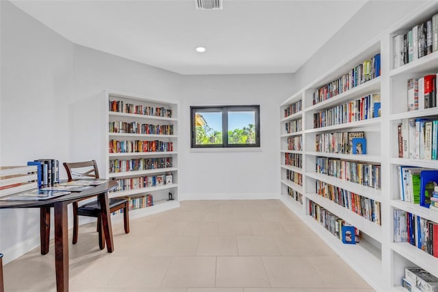 living area featuring built in features and light tile patterned floors