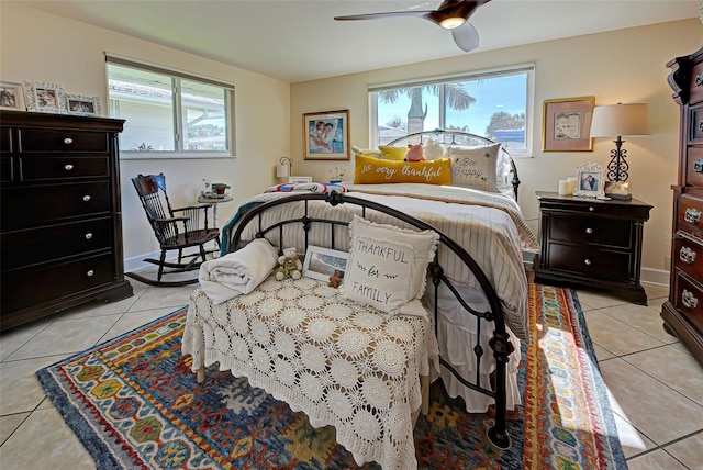 bedroom with ceiling fan, light tile patterned floors, and multiple windows