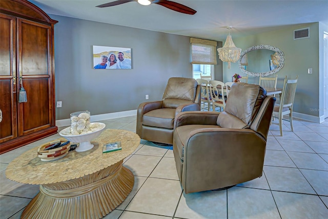 tiled living room featuring ceiling fan with notable chandelier