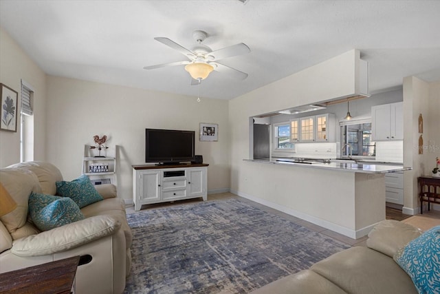 living room with ceiling fan and sink